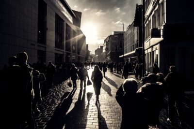People walking down a Liverpool street into a low sun.